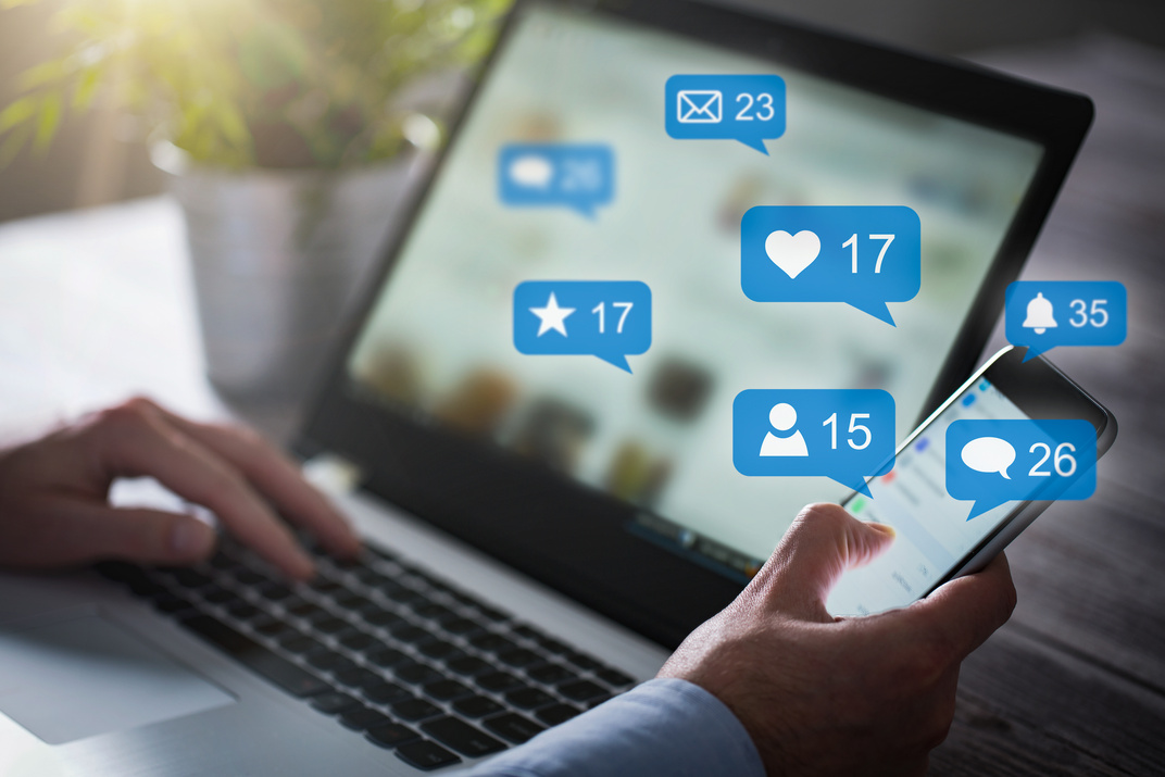 how to use social media to grow your business. The image shows a man looing at a laptop screen full of social media notifications. This implies that his customers are engaging with his content due to great content.